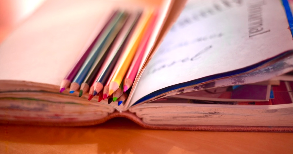 Colored pencils and an empty journal. Credit: Cаrolinе Lаgattuа/Stocksy